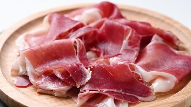 Spanish serrano ham rotating on wooden table