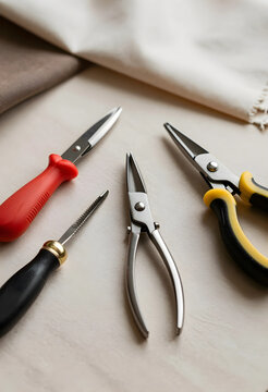 Crafting and hobby tools, various pliers and scissors for jewelry making or textile work on a light background