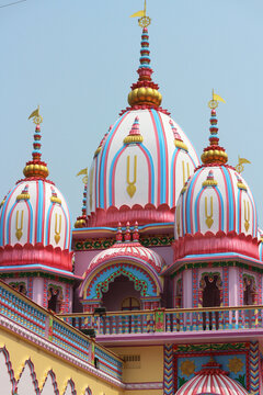 Majestic domes of a Hindu Vaishnava temple adorned with the sacred Tilaka symbol against the sky.