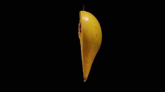 Cut Canistel Fruit Reveals Glossy Brown Seeds Against Black Background, Showing Fresh Tropical Produce and Natural Food Texture