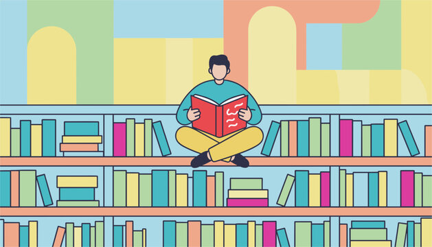 Young man sitting cross legged on a wooden bookshelf while reading an open red book in a colorful library setting.