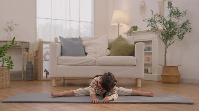 Child Practicing Seated Forward Bend on Yoga Mat in Bright Living Room with Plant and Daylight, Gentle Exercise for Flexibility, Wellness, Calm Movement, Mindful Stretching, Peaceful Home Scene