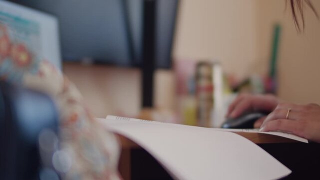 Office Worker Using Laptop with Paper Document