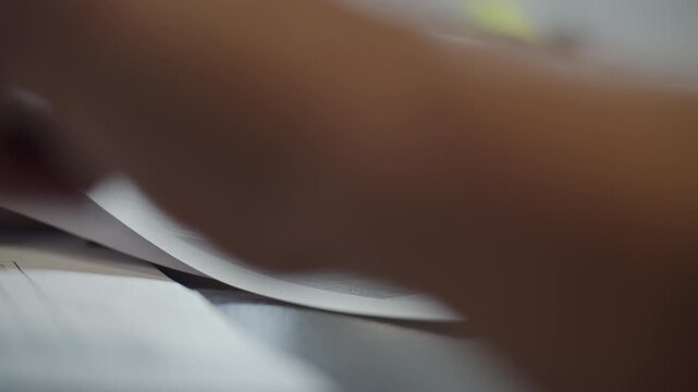 Hand Reviewing Paper Document at Office Desk