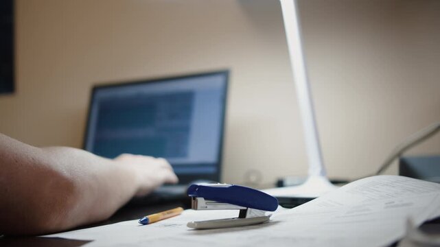 Hand Stapling Documents at Office Desk