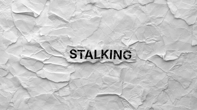 Crumpled piece of paper with word Stalking on torn crumpled white paper pieces background