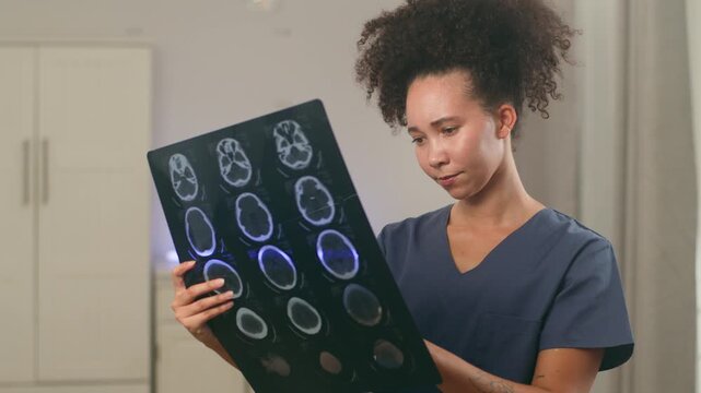 Focused Black Woman Doctor Analyzing a Brain Scan with a Pen in a Modern Medical Setting