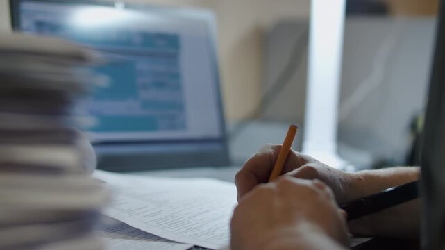 Office Worker Writing Notes on Paper Documents