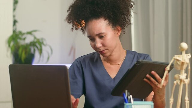 Focused Black Woman Medical Professional Using Tablet And Laptop In Modern Office