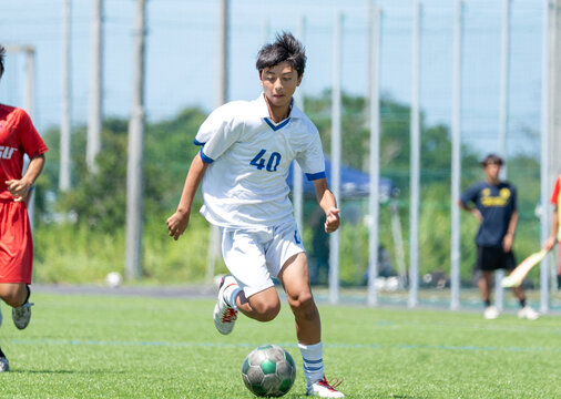 サッカーの試合をする中学生の男の子