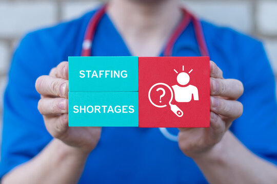 Concept of staffing shortages. Health care labor market crisis and recruitment challenges, magnifying glass over human resources.
