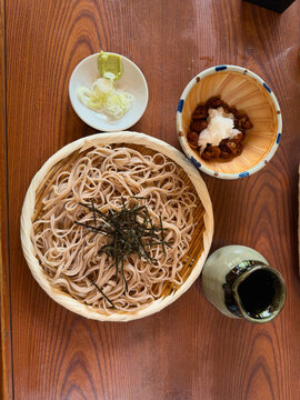 Traditional Japanese soba noodles served on a bamboo tray with nori, accompanied by mushrooms, grated daikon, wasabi and scallions, photographed at a restaurant near Jindaiji Temple in Chofu, Tokyo