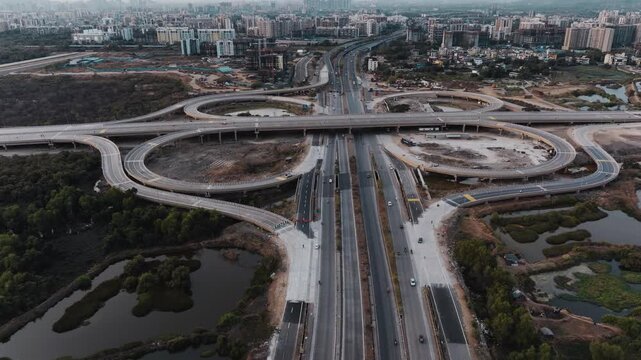 Aerial view of Navi Mumbai, Maharashtra, India, showcasing modern highway interchanges, elevated roads, green surroundings, water bodies, and rapidly developing urban areas.