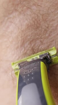 Electric Trimmer Shaves Armpit Hair in Extreme Close Up, Showing Personal Grooming and Body Care Vertical video.