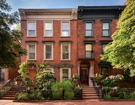 tall brownstone townhouse with stoop and side garden
