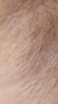 Razor Removes Body Hair from Skin in an Extreme Close Up, Showing Personal Grooming and Hygiene Care Vertical video.