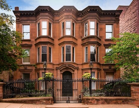 historic brownstone facade with front stoop and iron fence