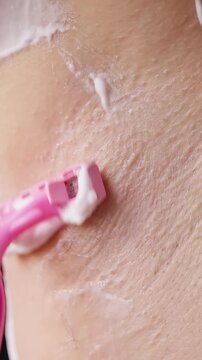 Person Shaves a Cream Covered Neck With a Pink Razor, Extreme Close Up Shows Personal Grooming and Hygiene Routine Vertical video.