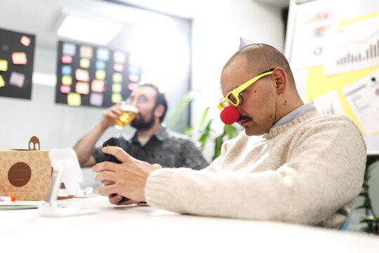 Business team engages in creative brainstorming session with humor and fun elements in a modern office space during the afternoon