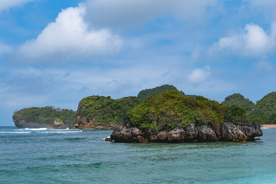 Scenic Gatra Beach in Malang, East Java, Indonesia, featuring clean sandy shores, calm blue seawater and beautiful small islands surrounded by pristine tropical coastal scenery