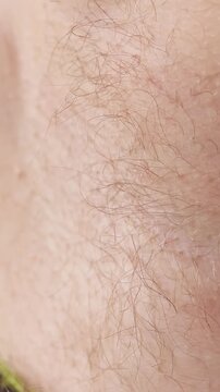 Man Trims Armpit Hair With Electric Trimmer in Closeup, Personal Grooming and Hygiene Routine Vertical video.