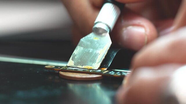 Technician repairing a laptop connector with precision tools close up detail workbench