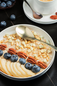 Oatmeal. Bowl of oatmeal porridge with blackberry, bananas and chia seeds on gray concrete old table background. Top view in flat lay style. Natural ingredients. Hot healthy breakfast and diet food