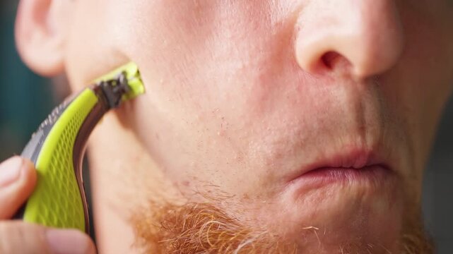 Man Shaves Cheek With Electric Razor in Close Up, Showing Daily Facial Grooming and Personal Hygiene