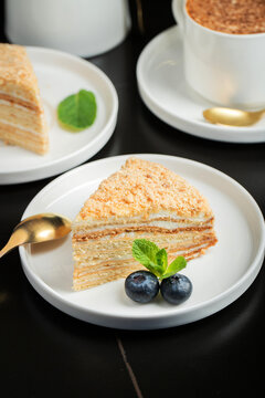Medovik. Honey cake made from honey cakes with whipped sour cream, decorated with berries, pomegranate and flowers