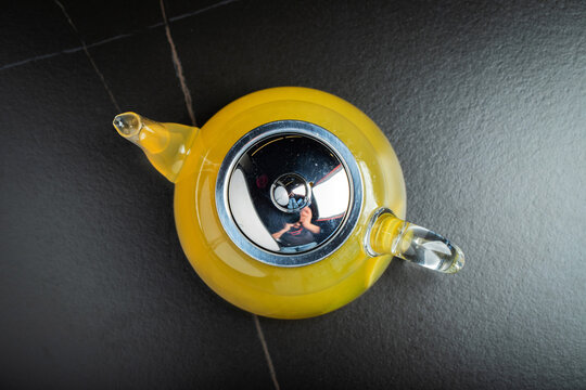 Fruit tea with mango and mint in a glass teapot on the table
