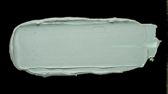 Light mint green cosmetic cream makeup swatch texture isolated on black background with cosmetic, foundation
