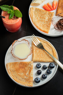 Pancakes with blueberry and honey on a white plate
