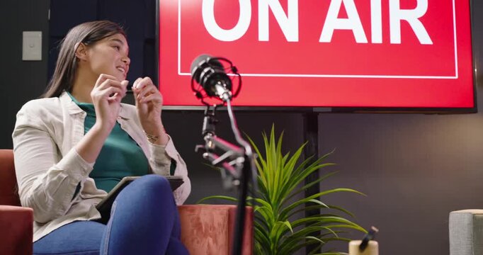 Podcast host and guests recording chat while host leaning revealing couch tablet ON AIR laughing
