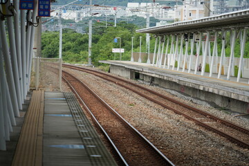 Fototapeta premium Empty railway platform and curved tracks extending forward.