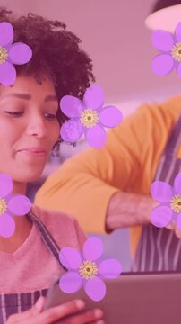Animation of flowers over happy diverse couple cooking together