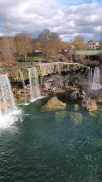Vertical panning left shot of Pedrosa de la Tobalina waterfall and river in Burgos Spain