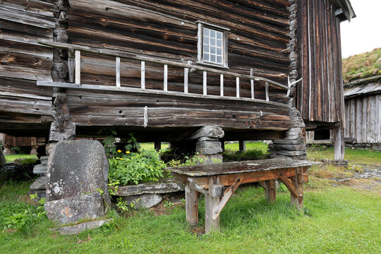 Ein norwegisches , historisches h&ouml;lzernes Bauernhaus mit Leiter auf Steins&auml;ulen, welche F&auml;ulnis des Holzes verhindern