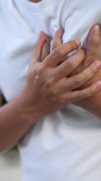 Men have chest pain. hand hold chest with heart attack symptoms, caused by heart disease, leak, dilatation, enlarged coronary heart, press on the chest with a painful expression.	