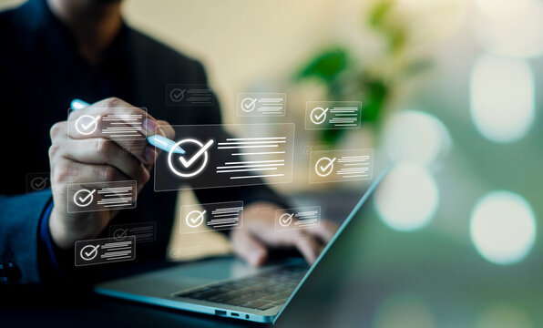 Businessman using digital document management system and checklist interface for paperless office workflow. Concept of online file processing, approval, and corporate e-signature.