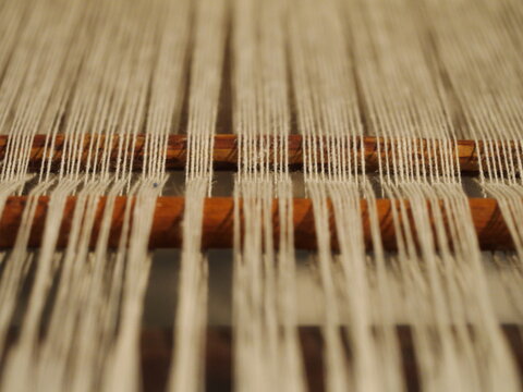 Close up of a wooden stick with a bunch of white yarn on it