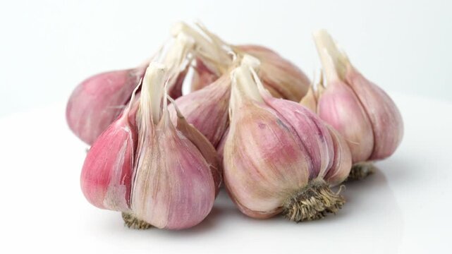 Unpeeled fresh organic garlic bulbs rotating in close up view. Harvesting and agriculture. Farming. Vegetables.