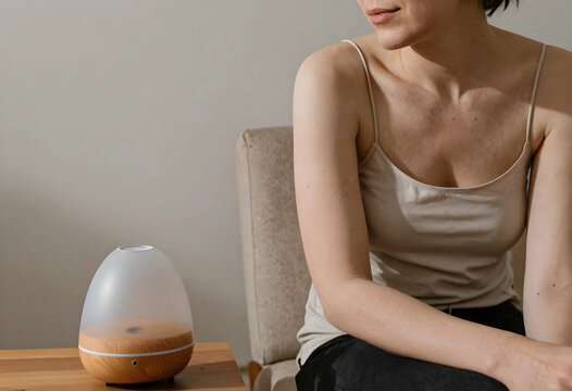 Aromatherapy and wellness at home, woman relaxing with essential oil diffuser for stress relief and self care