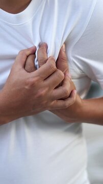 Men have chest pain. hand hold chest with heart attack symptoms, caused by heart disease, leak, dilatation, enlarged coronary heart, press on the chest with a painful expression.