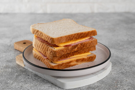 Ham and cheese sandwich on a plate on a gray concrete background