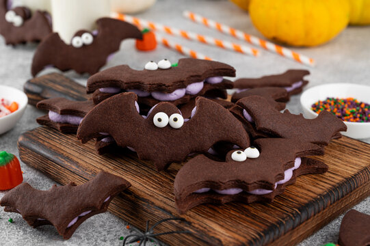 Halloween cookies. Chocolate sandwich cookies in the shape of a bat with eyes and butter cream. Funny food idea. Top view.