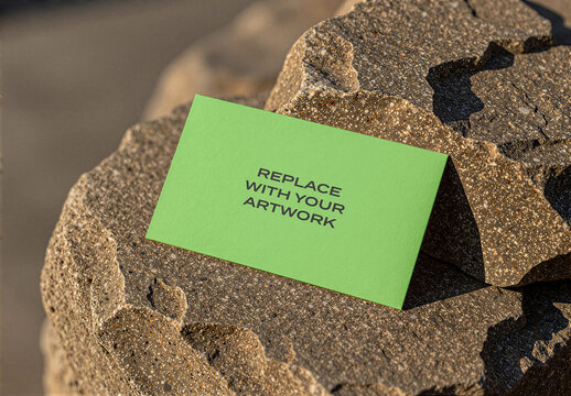 Business card mockup on a textured stone surface in an outdoor setting with natural light, realistic stationery presentation, landscape environment, commercial product display