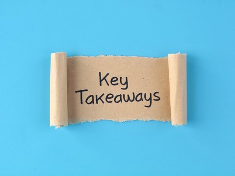 Key takeaways text handwritten on a brown paper scroll over bright blue background. Perfect concept for main points, business summaries, learning conclusions, and key points overview.