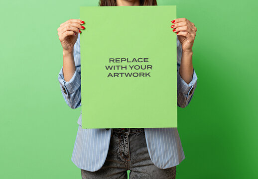 Vertical poster mockup held by a person in studio setting with green background, realistic print presentation template for graphic design, branding, advertising, editorial content, wall art