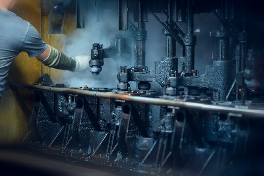 Factory Worker Maintaining Industrial Glass Molding Machinery. Motion blur is used for dynamics.