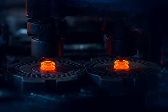 Close Up of Molten Glass Forming Bottle Necks with Motion Blur. Motion blur is used for dynamics.
